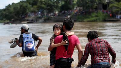 Migrants struggle to cross the river from Guatemala to Mexico in Ciudad Hidalgo. Reuters