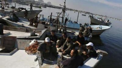 Palestinian workers wait at the port in Gaza City on Dec 1 2008, for the arrival of a Libyan aid ship.