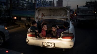 Afghan boys ride in the boot of a car. Photo: AP