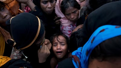 A Rohingya Muslim child cries as she stands amid a crowd of elders to receive food being distributed near Balukhali refugee camp in Cox's Bazar, Bangladesh / AP