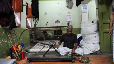 A labourer prepares silk threads before weaving Banarasi saris inside a handloom factory in Rajapura Varanasi. (Sanjay Kanojia / AFP Photo / April 22, 2014)