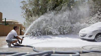 Ben Elliott-Scott, managing director of Desert Snow, sprays a typical street side scene in Jumeirah with a artificial snow typically used on movie sets and stages to recreate a snow scene. Antonie Robertson / The National