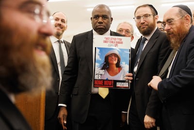 Foreign Secretary David Lammy holds a placard showing hostage Emily Tehila Damari, during a visit to South Tottenham United Synagogue in London. AFP