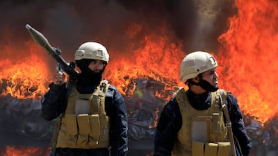 Houthi guards watch a burning pile of confiscated drugs, in the northern governorate of Saada, Yemen. EPA
