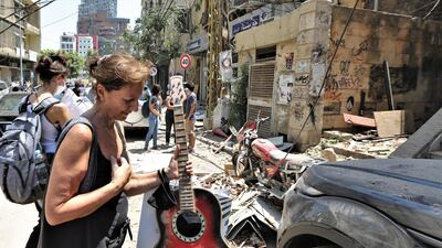 People carry belongings after evacuating their damaged housing units at area of Mar Mikhael and Gemayzeh. EPA