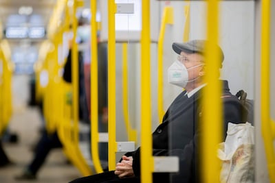 A man sits in the subway wearing an FFP2 mask in Berlin, Germany, Wednesday, Jan. 20, 2021.. During the federal-state talks on the measures against the Corona pandemic, some rules were tightened. For example, the more protective FFP2 masks or surgical masks must be worn on buses and trains and when shopping. The federal states decide for themselves when the new rules will apply. (Christoph Soeder/dpa via AP)
