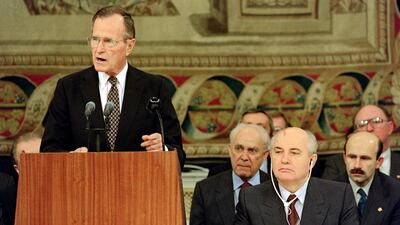 Bush addresses delegations as Gorbachev listens. AFP