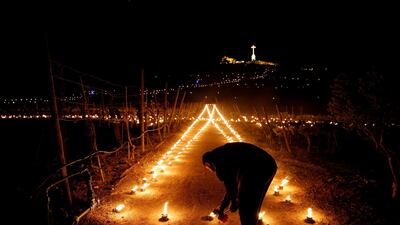 A volunteer lights flaming torches during a Seven Churches Visitation pilgrimage as part of Holy Week activities on the hill leading to Laferla Cross, one of the highest points on the Maltese islands, on Maundy Thursday outside the village of Siggiewi, Malta. Reuters