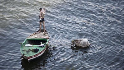 An Egyptian man washes himself on a boat in the River Nile, Cairo, Egypt. Khaled Desouki / AFP