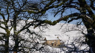 Tuesday recorded more snowfall in the north of the country, with this cottage near Carrshield in Northumberland blanketed overnight. PA