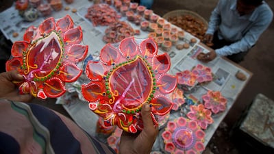 Vendors arrange decorated earthen lamps on a street ahead of Diwali festival in Gauhati, India, Saturday, Oct. 19, 2019. People buy earthen lamps to decorate their homes during Diwali, the annual Hindu festival of lights which will be celebrated on Oct 27. AP