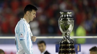 Argentina's Lionel Messi walks by the Copa America trophy after receiving the runners-up medal on Saturday after the South American tournament's final. Natacha Pisarenko / AP