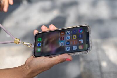 A customer shows her iPhone 12 in front of the Apple Store on the Champs Elysees Avenue in Paris. EPA