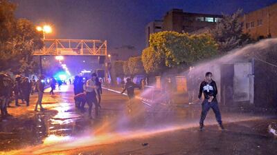 Lebanese security forces use a water cannon to disperse protesters outside the Serail, headquarters of the Governorate of North Lebanon. AFP