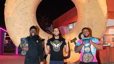 The New Day and Mansoor pose in front of Randy's Donuts at The Boulevard in Riyadh. Courtesy WWE