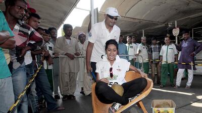 Imthishan Giado, standing, and Ujala Ali Khan navigate the wheelbarrow challenge at the Detour City Hunt. Jeffrey E Biteng / The National