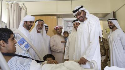 Sheikh Mohammed, second right, Sheikh Mansour and Sheikh Hamdan, right, smile as they talk to an injured serviceman and his family.