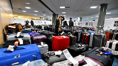 Passengers search for luggage following flight cancellations and delays caused by winter storms, at Vancouver International Airport, British Columbia, western Canada. Reuters