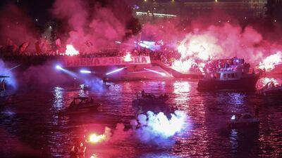 Supporters light flares on the bank of the Sava river on May 22, 2021, after Red Star Belgrade won the Serbian SuperLiga. AFP