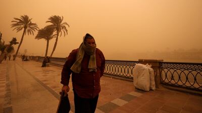 A man covers his face during a sandstorm near the River Nile in Cairo, Egypt. REUTERS