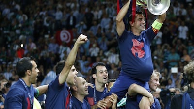 Barcelona's Xavi is carried by his teammates as he holds the trophy after the Uefa Champions League final against Juventus at the Olympic stadium in Berlin Saturday, June 6, 2015. Barcelona won the match 3-1. (AP Photo/Luca Bruno)