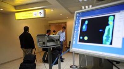Health officials examine incoming passengers with an infrared heat scanner at Abu Dhabi International Airport.