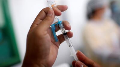 A health worker prepares a coronavirus disease vaccine shot as the UK considers targeting new groups. Reuters