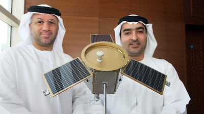 Mohamed Al Ghanim, board chairman of EIAST (Emirates Institute for Advanced Science and Technology) left and Ahmed Al Mansoori, director general of EIAST, with a model of the DubaiSat-1 satellite at a press conference announcing the successful launch of the satellite. The National