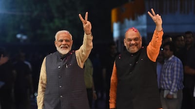 TOPSHOT - Indian Prime Minister Narendra Modi (L) and president of the ruling Bharatiya Janata Party (BJP) Amit Shah gesture as they celebrate the victory in India's general elections, in New Delhi on May 23, 2019. Hindu nationalist Prime Minister Narendra Modi claimed victory on May 23 in India's general election and vowed an "inclusive" future, with his party headed for a landslide win to crush the Gandhi dynasty's comeback hopes. / AFP / Money SHARMA