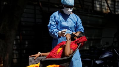 A healthcare worker takes a swab from a migrant laborer for a rapid antigen test in New Delhi. Reuters