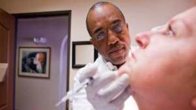 Dr Herbert Parris of Denver injects Perlane, a filter gel used to plum specific areas of skin, into the face of Gail Kane.