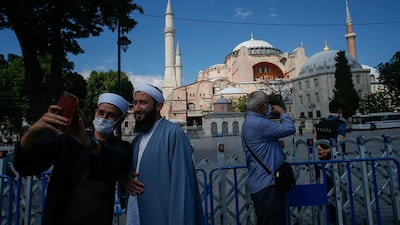 People use their mobile to take a selfie picture outside the now closed Byzantine-era Hagia Sophia, one of Istanbul's main tourist attractions in the historic Sultanahmet district of Istanbul, Saturday, July 11, 2020. AP