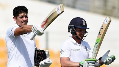 England captain Alastair Cook, left, standing next to teammate Ian Bell, waves his bat after reaching a century during Day 3 of the first Test against Pakistan at Zayed Cricket Stadium in Abu Dhabi. Hafsal Ahmed / AP Photo