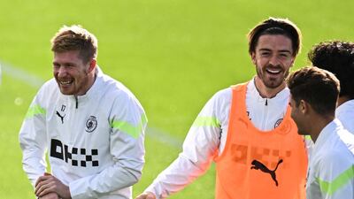 Kevin De Bruyne laughs with Jack Grealish during training. AFP