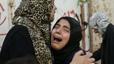 A Palestinian women weeps for relatives killed near a United Nations school.