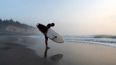 A surfer observes a moment of silence during the Iwasawa Surfing Games at Iwasawa beach, Fukushima. Getty Images