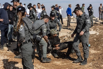 An Israeli youth is dragged out of the settlement by police. AFP