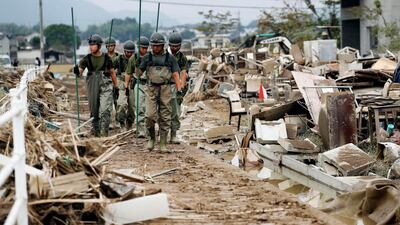 Japan Ground Self-Defense Force members search missing people after flooding caused by heavy rains in Kurashiki, Okayama prefecture, southwestern Japan, Thursday, on July 12. Kyodo News via AP