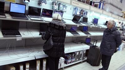 Customers look at laptops in a shop in Klintsy southwest of Moscow. Belarusians have started to go to Russia for purchasing electronics, because of a lower prices as a result of the ruble's plunge. Sergei Gapon / AFP
