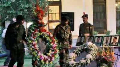 Afghan soldiers carry a bouquet during a memorial ceremony for Indian Embassy employees killed in a suicide attack in Kabul.