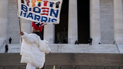 Kyriaki Chris, of Virginia, waves a Biden-Harris flag near the Lincoln Memorial in Washington, DC. AFP