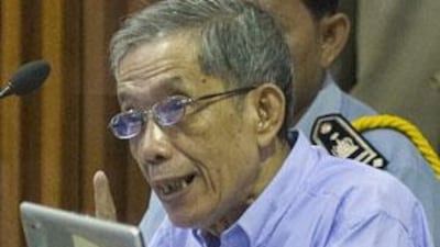 Kaing Guek Eav, also known as Duch, speaks to his attorneys moments before the start of his trial on the outskirts of Phnom Penh.