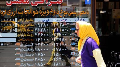 An Iranian woman walks by a money exchange office in the capital Tehran. AFP