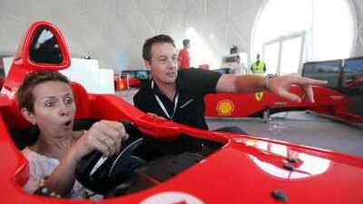 bu Dhabi / Natalie Hamilton an avid F1 fan takes spin behind a mock F1 car simulator with a little help from Phil Williams at the F1 Fan Zone on Abu Dhabi Corniche.