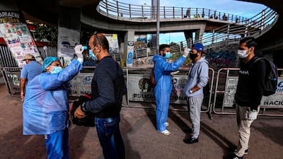 People get their temperature checked by health workers as a preventive measure against the spread of the new coronavirus in Bogota, Colombia. Latin America had more than 20,000 cases of Covid-19 as of April 1, 2020 - double the figure from five days earlier, according to an AFP tally. AFP