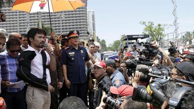 Pacquiao, left, speaks to Filipino supporters during a welcoming parade in Manila. Ritchie B Tongo / EPA