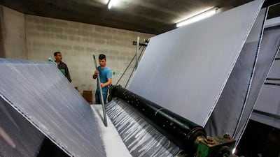 A worker operates a textile washing machine. AFP