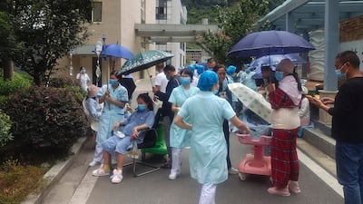 Medical workers move patients to safety at Renmin Hospital, in Yaan city, after the quake struck. Xinhua News Agency/AP