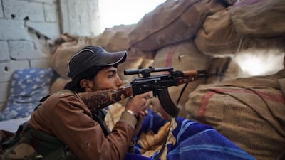 A Kurdish fighter holds a position against ISIL in the besieged Syrian border town of Kobani on Friday. Ahmed Deeb / AFP