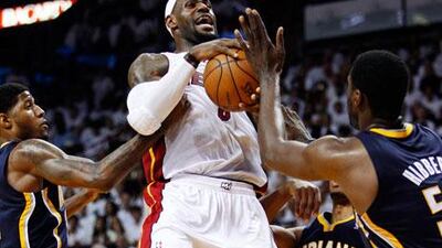 LeBron James, centre, tries to shoot under pressure. The Miami Heat player and his teammates missed the presence of the injured Chris Bosh last night.